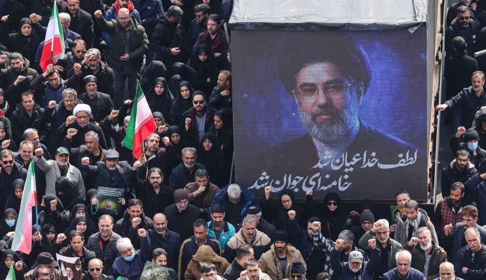 TOPSHOT - A screen displays a portrait of Iran's new supreme leader Mojtaba Khamenei during the funerals of Iran's Revolutionary Guards Corps (IRGC) commanders, army commanders and others killed in the early days of the United States and Israeli strikes on Iran, at Enghelab Square in Tehran on March 11, 2026. Washington launched strikes with Israel on Iran on February 28, sparking retaliatory strikes by Tehran against Israel and US bases across the Gulf region. (Photo by ATTA KENARE/AFP)/Attention editors: Photo taken with approval from the Ministry of Culture and Islamic Guidance (Ershad) --AFP covers the war in the Middle East through its extensive regional network, including bureaus in Tehran, Jerusalem, and several neighboring countries. Since the start of the conflict, journalists have been working under increasingly restrictive conditions. Authorities in several countries have limited reporters' movements, photo and live video coverage from sensitive locations. Some governments and armed groups have banned images of missile or drone strikes and other security-related sites./