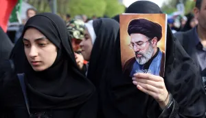 Iranians, one holding the image of Iranian supreme leader Mojtaba Khamenei, rally during a memorial, 40 days after the US-Israeli strike on a children?s school in the southern city of Minab on the first day of the war that killed at least 165 people, most of them children, in Tehran on April 7, 2026. On February 28, Israel and the United States launched strikes on Iran, killing its supreme leader and triggering a war that spread across the Middle East. (Photo by AFP)/