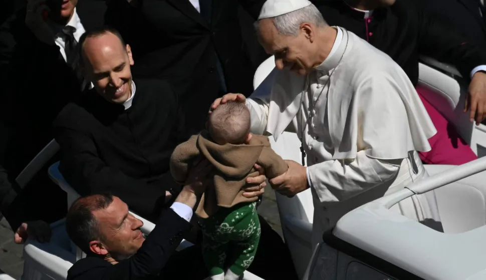 Pope Leo XIV blesses a baby presented to him from the popemobile after the Easter Mass as part of the Holy Week celebrations, at St Peter's square in the Vatican on April 5, 2026. (Photo by Andreas SOLARO/AFP)
