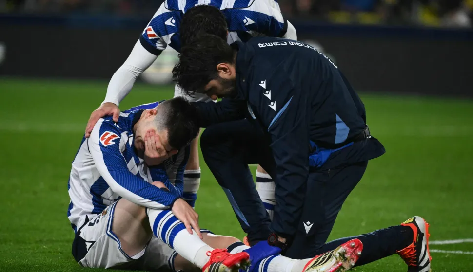 Real Sociedad's Spanish defender #05 Igor Zubeldia (L) receives assistance after sustaining an injury during the Spanish league football match between Villarreal CF and Real Sociedad at La Ceramica Stadium in Vila-real on March 20, 2026. (Photo by JOSE JORDAN/AFP)