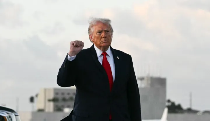US President Donald Trump makes a fist upon arrival at Miami International Airport in Miami, on April 11, 2026. Trump is traveling to Florida to attend a UFC event and spend the weekend at his Mar-a-Lago residence. (Photo by Jim WATSON/AFP)