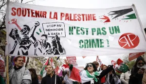 Protesters hold a banner reading "Supporting Palestine is not a crime" and "Stop genocide in Gaza" as they take part in a rally against the Yadan bill, which aims to combat new forms of anti-Semitism, in Paris on April 12, 2026. The proposed bill, named after French lawmaker from the presidential camp Caroline Yadan and will be debated next April 16 and 17, aims to combat "new forms" of anti-Semitism and has met with strong reservations. Its opponents, particularly on the left, argue that it would threaten freedom of expression and perpetuate a conflation of Jews and Israel. (Photo by Ian LANGSDON/AFP)