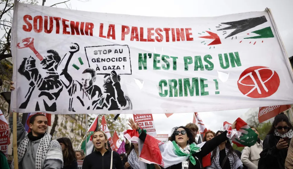 Protesters hold a banner reading "Supporting Palestine is not a crime" and "Stop genocide in Gaza" as they take part in a rally against the Yadan bill, which aims to combat new forms of anti-Semitism, in Paris on April 12, 2026. The proposed bill, named after French lawmaker from the presidential camp Caroline Yadan and will be debated next April 16 and 17, aims to combat "new forms" of anti-Semitism and has met with strong reservations. Its opponents, particularly on the left, argue that it would threaten freedom of expression and perpetuate a conflation of Jews and Israel. (Photo by Ian LANGSDON/AFP)