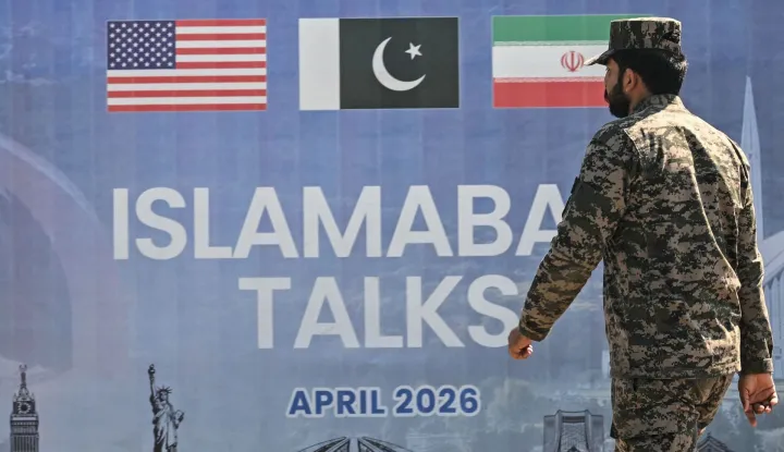 A Pakistani Ranger walks past a billboard for the US-Iran peace talks in Islamabad on April 12, 2026. Iran and the United States failed to reach an agreement to end the war in the Middle East, US Vice President JD Vance said on April 12 after marathon talks in Islamabad, adding that he was leaving negotiations after giving Tehran the "final and best offer". (Photo by Farooq NAEEM/AFP)