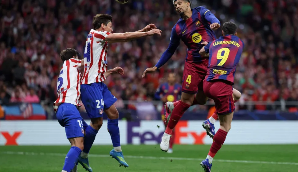 Barcelona's Uruguayan defender #04 Ronald Federico Araujo da Silva heads the ball with Atletico Madrid's Spanish defender #24 Robin Le Normand during the UEFA Champions League quarter final second leg football match between Club Atletico de Madrid and FC Barcelona at Metropolitano Stadium in Madrid on April 14, 2026. (Photo by Thomas COEX/AFP)