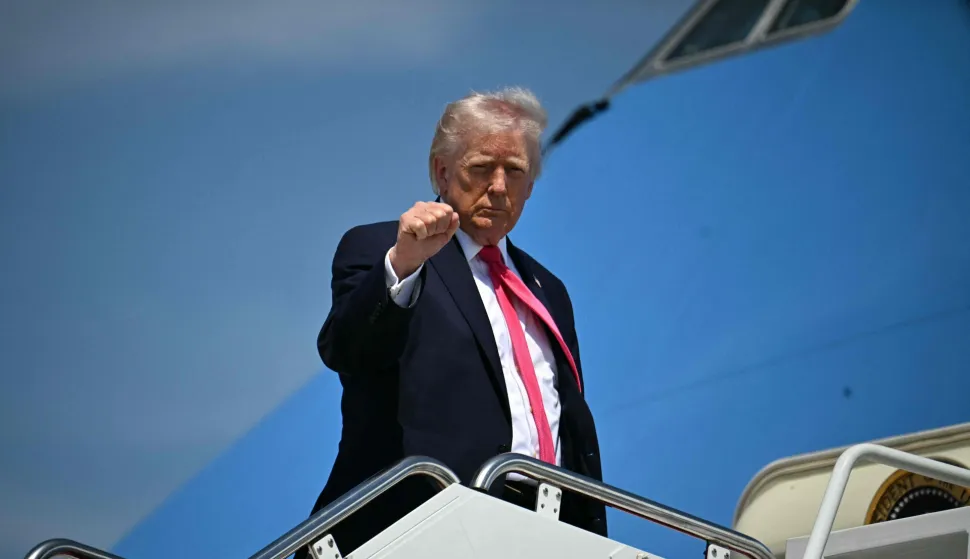 US President Donald Trump raises his fist as he boards Air Force One at Joint Base Andrews in Maryland on April 16, 2026. Trump is headed to Las Vegas where he will deliver remarks on his "no tax on tips" policy. (Photo by Jim WATSON/AFP)