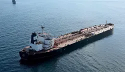 (FILES) This aerial picture taken on October 1, 2025 off the coast of the western France port of Saint-Nazaire shows the tanker Boracay from Russia's so-called "shadow fleet" suspected of being involved in drone flights over Denmark which sailed off the Danish coast between September 22 and 25, with a boat of the French Navy in the background. The Chinese captain of the Boracay, a tanker from the Russian shadow fleet that was seized in September by the French navy off the coast of Brittany, was sentenced on March 30, 2026 to one year in prison by the Brest criminal court for "failing to comply with orders."Chen Zhangjie, 39, who was not present when the judgment was delivered, was also fined 150,000 euros. The court issued an arrest warrant against him.Named the Pushpa or Boracay, the Benin-flagged vessel, which is blacklisted by the European Union for being part of Russia's sanction-busting "shadow fleet", has been immobilised for several days off the French coast. (Photo by Damien MEYER/AFP)