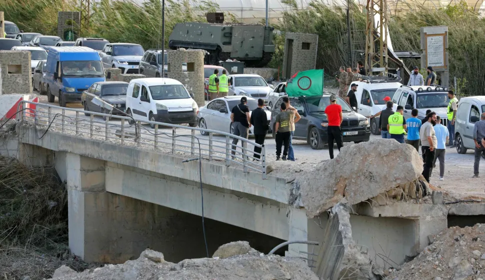 Displaced residents travel back to their homes past the ongoing restoration work at the site of Israeli strikes that targeted the Qasmieh bridge built over the Litani river in the southern Lebanese area of Al Qasmiyeh on April 17, 2026. A 10-day ceasefire deal struck between Lebanon and Israel took effect on April 17, sending displaced residents streaming south towards their homes, even as the Lebanese army warned of "a number of violations" in the area. (Photo by Ibrahim AMRO/AFP)
