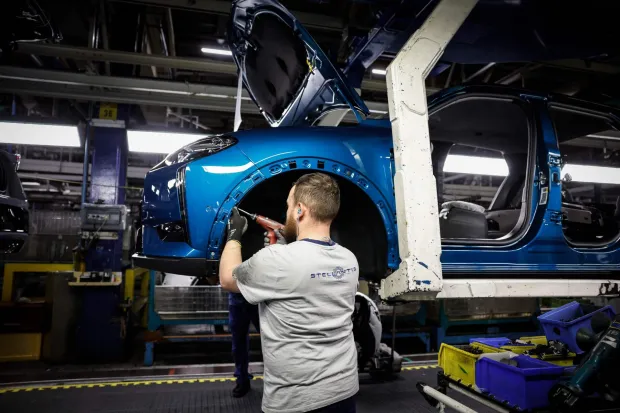A staff member works on the car production line at the Stellantis multinational car manufacturer's plant in Poissy, west of Paris, on April 15, 2026. Automaker Stellantis will cease automobile production at its historic Poissy plant (Yvelines) after 2028. The site will be converted into a parts manufacturing and vehicle dismantling center, retaining 1,000 of the current 2,000 jobs, the group announced on April 16, 2026. (Photo by Simon Wohlfahrt/AFP)