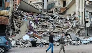 This picture taken on April 9, 2026, people walking at the site of the previous day's Israeli airstrikes that targeted southern Beirut?s al-Shiyah neighbourhood. The Israeli military said it struck a Hezbollah commander in Beirut on April 8, after Lebanese state media reported that Israel had targeted a residential neighbourhood in the capital. (Photo by AFP)