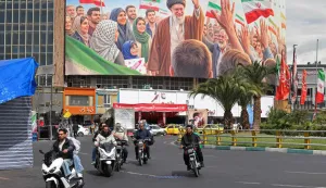 Motorists ride past a giant billboard of slain Iranian supreme leader Ayatollah Ali Khamenei at the Valiasr Square in Tehran on April 19, 2026. The strategic Strait of Hormuz was again closed on April 19 in the stand-off between Iran and the United States, with Iran's powerful parliament speaker signalling a final peace deal remained "far" off despite some movement in negotiations. (Photo by ATTA KENARE/AFP)/