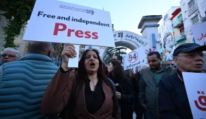 Journalists hold placards during a demonstration in front of the SNJT headquarters in Tunis on April 24, 2026. Several dozen journalists gathered in Tunis on April 24 to defend press freedom and in support of the Franco-Tunisian columnist Mourad Zeghidi, who has been in detention since 2024. (Photo by FETHI BELAID/AFP)