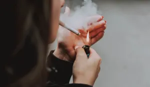 A selective closeup shot of a female lighting up a cigarette with a lightercigarete pu&scaron;enje ilustracija