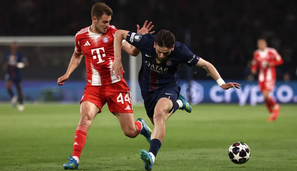 Bayern Munich's Croatian defender #44 Josip Stanisic fights for the ball with Paris Saint-Germain's Georgian forward #07 Khvicha Kvaratskhelia during the UEFA Champions League semi-final first leg football match between Paris Saint-Germain (PSG) and Bayern Munich at the Parc des Princes in Paris on April 28, 2026. (Photo by FRANCK FIFE/AFP)