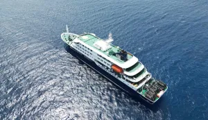 This aerial picture shows a general view of the cruise ship MV Hondius stationary off the port of Praia, the capital of Cape Verde, on May 4, 2026. Strict precautionary measures including isolation are in place on a cruise ship anchored off Cape Verde on which a suspected outbreak of hantavirus has killed three people, the cruise operator said on May 4, 2026.The Canary Islands are being "considered" for disembarkation of the boat, which has 149 people of 23 nationalities on board, after Cape Verde refused entry, Oceanwide Expeditions said in a statement. (Photo by AFP)