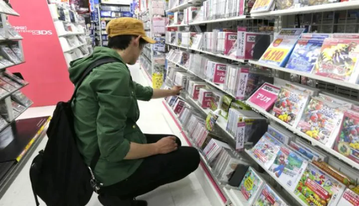 epa04736401 A customer checks game software for the world's largest video game company Nintendo Co., Ltd.'s gaming console Nitendo 3DS, at a discount chainstore in Tokyo, Japan, 07 May 2015. Nintendo posted on 07 May a group operating profit of 24.77 billion yen (about 207.5 million US dollar) for the 2014 fiscal year ending on 31 March, 2015, their first operating profit in four years. EPA/KIMIMASA MAYAMA