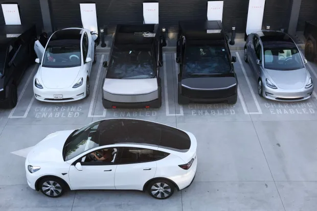 (FILES) Tesla electric vehicles, including the Cybertruck, charge at stations during the opening of the Tesla Diner and Drive-In restaurant and Supercharger on Santa Monica Blvd in the Hollywood neighborhood Los Angeles, California on July 21, 2025. Tesla reported higher first-quarter profits Wednesday, pointing to recovering demand in North America as it pursues significant investments in autonomous transport and artificial intelligence. (Photo by Patrick T. Fallon/AFP)