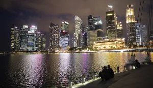 epa08479133 People look at the night view of the Merlion park and the Central Business District (CBD) area in Singapore, 11 June 2020. Singapore has started to ease its circuit breaker measures against Covid-19 since 02 June and reopen the economy in phases. EPA/HOW HWEE YOUNG