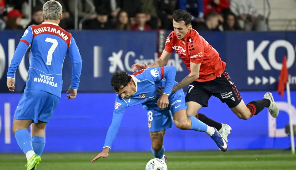 Osasuna's Croatian forward #17 Ante Budimir fights for the ball with Atletico Madrid's Spanish defender #18 Marc Pubill during the Spanish league football match between CA Osasuna and Club Atletico de Madrid at El Sadar Stadium in Pamplona on May 12, 2026. (Photo by ANDER GILLENEA/AFP)