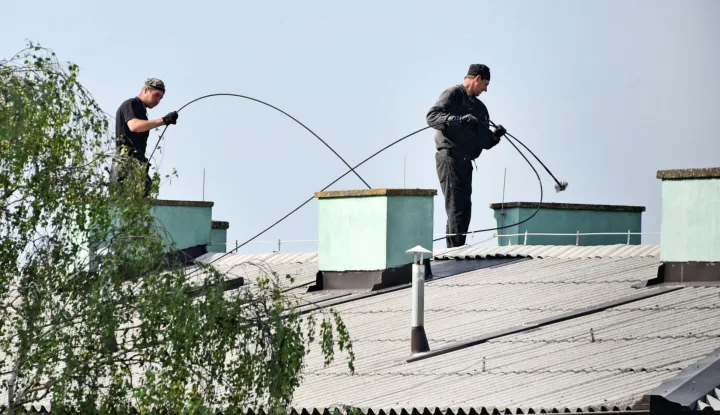 slavonija...vinkovci...18.05.2022.dimnjacar na krovu zgrade u ulici andrije hebranga na svom, u proljece redovnom poslu, ciscenja dimnjaka; foto Gordan Panić