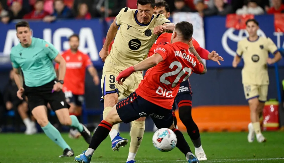 Barcelona's Polish forward #09 Robert Lewandowski is challenged by Osasuna's Spanish midfielder #20 Javi Galan during the Spanish league football match between CA Osasuna and FC Barcelona at El Sadar Stadium in Pamplona on May 2, 2026. (Photo by ANDER GILLENEA/AFP)