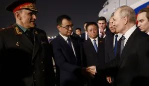 In this pool photograph distributed by the Russian state agency Sputnik, Russia's President Vladimir Putin is welcomed by Chinese Foreign Minister Wang Yi and other officials upon his arrival at Beijing Capital Airport in Beijing late on May 19, 2026. (Photo by Vladimir SMIRNOV/POOL/AFP)
