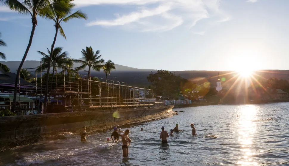 epa07089742 Athletes go for an early morning swim in Kailua Bay on the eve of race day in Kailua-Kona, Hawaii, USA, as the sun rises over Hualalai in the background, 12 October 2018 (issued 13 October 2018). International athletes gather for the 40th edition of the traditional Ironman triathlon race over a distance of 3.86 kilometers (2.4 miles) swimming in the Kailua Bay, a 180.2 kilometers (112 miles) cycling race along the Hawaii island's coast and a full marathon course over 42.2 kilometers (26.2 miles) with a finish in Kailua-Kona on 13 October 2018. EPA/BRUCE OMORI