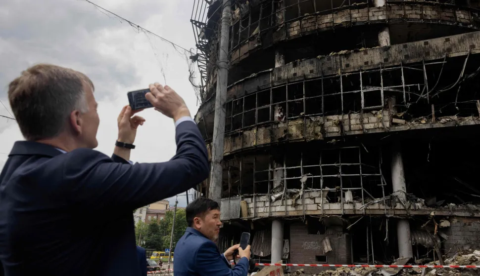 Members of diplomatic missions to Ukraine take pictures as they visit a heavily damaged shopping center following Russian strikes in Kyiv on May 25, 2026, amid the Russian invasion of Ukraine. (Photo by Tetiana DZHAFAROVA/AFP)