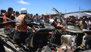 EDITORS NOTE: Graphic content/Members of the Palestinian civil defence inspect the wreckage of a vehicle targeted by an Israeli strike as bystanders watch in Khan Yunis in the southern Gaza Strip on May 26, 2026. Since October 10, a fragile US-sponsored truce in Gaza has largely halted the fighting between Israeli forces and Hamas, but both sides have alleged frequent violations. (Photo by Bashar Taleb/AFP)