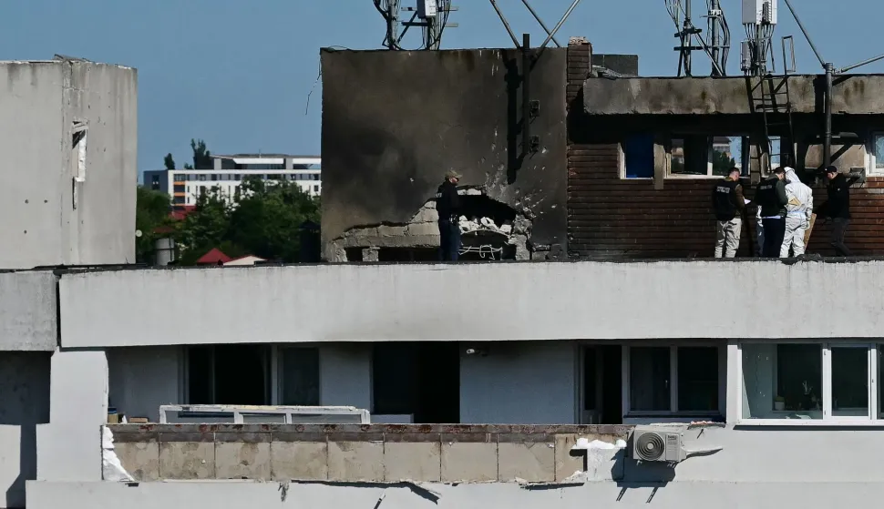 Police and forensic investigators stand on the rooftop as they examine the location of impact (C) over a damaged apartment after a Russian drone struck an apartment building in Galati, western Romania. A Russian drone wounded two people as it struck an apartment building in NATO-member Romania, its defence ministry said on May 29, 2026, the latest spillover from the four-year war into neighbouring states. (Photo by Daniel MIHAILESCU/AFP)