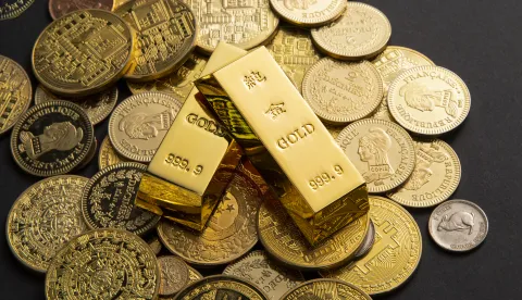 Golden coins, and gold bars scattered on a tablezlato, investicije, investicijsko, zlatne poluge, kapital, &scaron;tenja, novac, trži&scaron;te, ilustracijafreepik