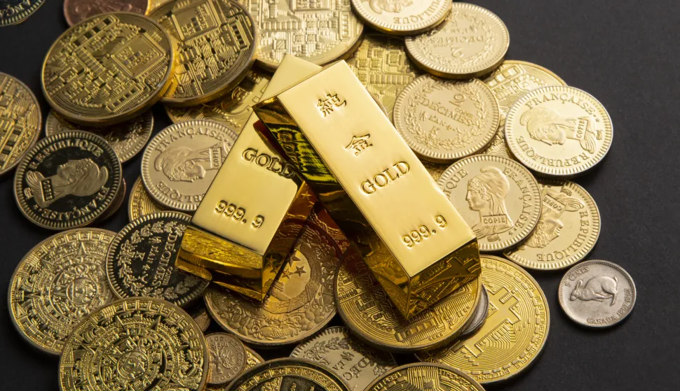 Golden coins, and gold bars scattered on a tablezlato, investicije, investicijsko, zlatne poluge, kapital, &scaron;tenja, novac, trži&scaron;te, ilustracijafreepik