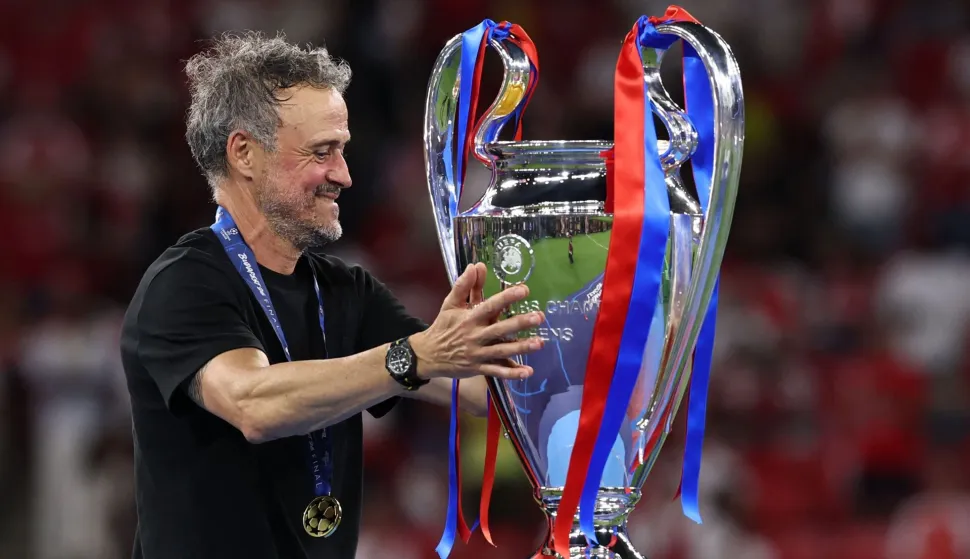 Paris Saint-Germain's Spanish head coach Luis Enrique touches the trophy after winning the UEFA Champions League final football match between Paris Saint-Germain (PSG) and Arsenal FC at the Puskas Arena in Budapest on May 30, 2026. Paris Saint-Germain beat Arsenal 4-3 on penalties to win their second consecutive Champions League title after a 1-1 draw in the final in Budapest on May 30. (Photo by FRANCK FIFE/AFP)