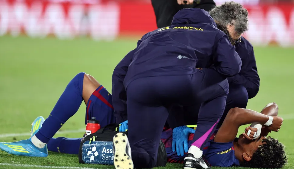 Barcelona's Spanish forward #10 Lamine Yamal receives medical attention after sustaining an injury during the Spanish league football match between FC Barcelona and RC Celta de Vigo at Camp Nou stadium in Barcelona on April 22, 2026. (Photo by Josep LAGO/AFP)