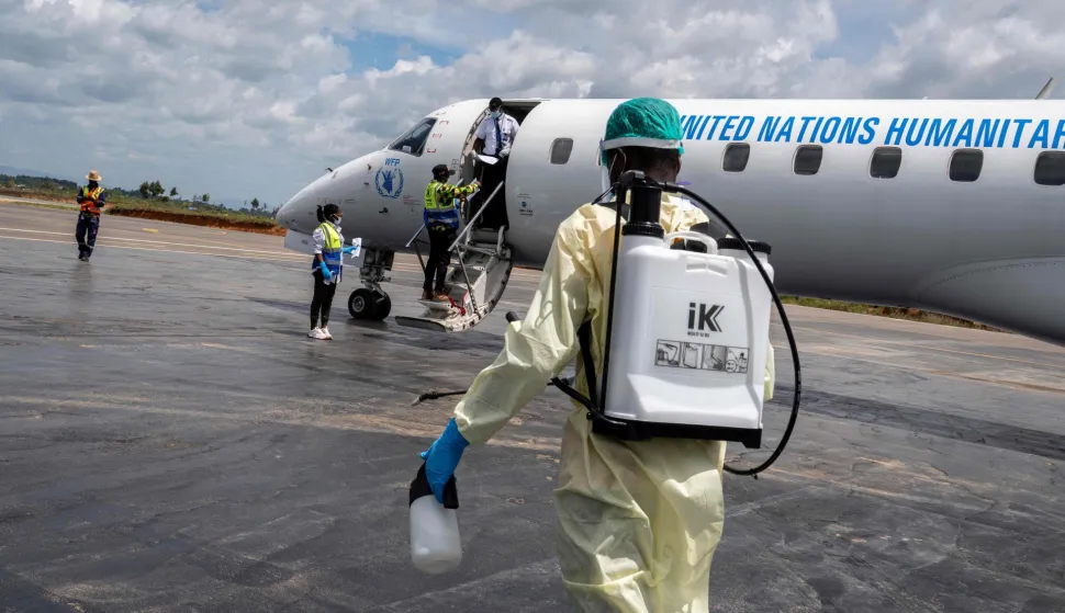 A health worker approaches an airplane to decontaminate passengers at Bunia Airport in eastern Democratic Republic of the Congo on June 3, 2026. On May 23, DRC authorities announced the temporary closure of Bunia Airport, located in the capital of Ituri Province, where the 17th Ebola outbreak is raging. The airport reopened on June 2. To date, 48 deaths have been reported among 321 confirmed cases of infection, according to Congolese health authorities and the WHO. (Photo by GLODY MURHABAZI/AFP)