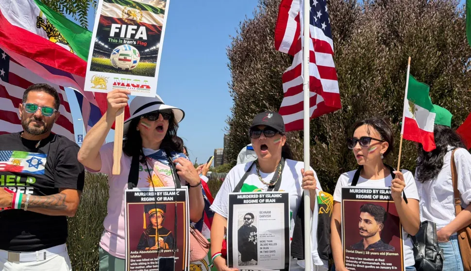 People wave US and pre-revolutionary Iranian flags as they protest the Iranian regime outside of Los Angeles Stadium (temporarly renamed from SoFi Stadium) in Inglewood, California, on June 7, 2026, ahead of the start of the 2026 FIFA World Cup. Iran are scheduled to open their Group G campaign against New Zealand in Los Angeles on June 15, before facing Belgium in the same city and then Egypt in Seattle. (Photo by Sarah LAI/AFP)