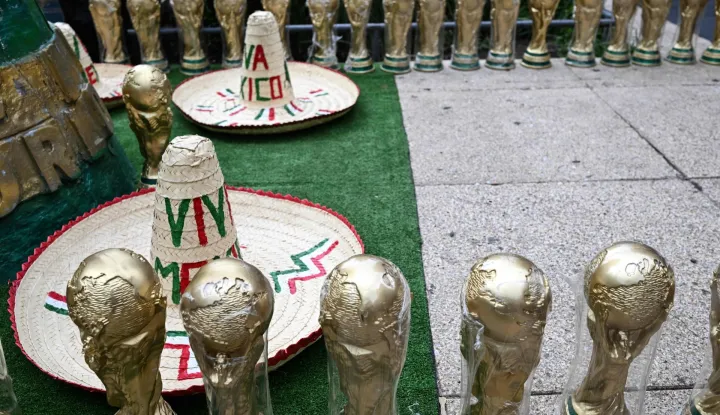TOPSHOT - Souvenirs shaped like the FIFA World Cup trophy and traditional Mexican hats are displayed for sale on a street in Mexico City on June 8, 2026. (Photo by Yuri CORTEZ/AFP)