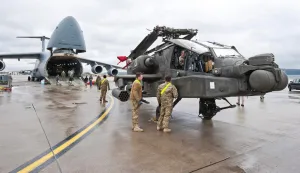 (FILES) An AH-64 Apache attack helicopter stands in front of a Galaxy C-5 transport plane at the US Air Base in Ramstein, western Germany, on February 22, 2017. Germany's defence minister on May 2, 2026, said the withdrawal of American troops from Germany had been expected and that Europe needed to do more to ensure its own security. The Pentagon on May 1, announced the withdrawal of about 5,000 troops from Germany within the next year, the latest rift in transatlantic ties over the Mideast war. (Photo by Martin GOLDHAHN/dpa/AFP)/Germany OUT