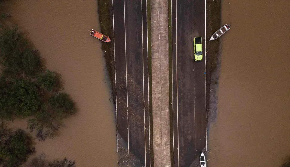 (FILES) Ariel view showing the flooded ERS-448 road in Canoas, Rio Grande do Sul state, Brazil, on May 13, 2024. In 2024 around two million people have been affected, more than 600,000 of whom were forced from their homes due to the disaster, which experts attribute to climate change and the El Nino weather phenomenon. In 2026 there is an 80-percent chance of the warming El Nino phenomenon developing between June and August, increasing the risk of extreme weather events, the World Meteorological Organization said on June 2, 2026. (Photo by Nelson ALMEIDA/AFP)
