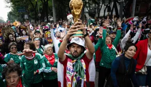A man holds up a replica of a World Cup trophy before the start of a Guinness World Record attempt for the world?s largest Mexican Wave in Mexico City on June 6, 2026. (Photo by Carl de Souza/AFP)