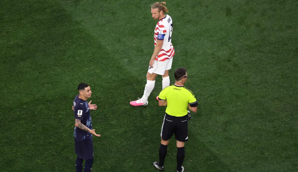 LOS ANGELES, CALIFORNIA - JUNE 12: Referee Danny Makkelie speaks to the Miguel Almiron #10 of Paraguay and Tim Ream #13 of the United States as VAR check is underway for 'mistaken identify' involving an tackle between the two players during the FIFA World Cup 2026 Group D match between USA and Paraguay at Los Angeles Stadium on June 12, 2026 in Los Angeles, California. Harry How/Getty Images/AFP (Photo by Harry How/GETTY IMAGES NORTH AMERICA/Getty Images via AFP)