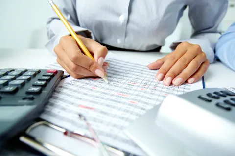 Photo of human hands holding pencil and ticking data in documents računovođa računovodstvo računi novac izvje&scaron;će bilanca 