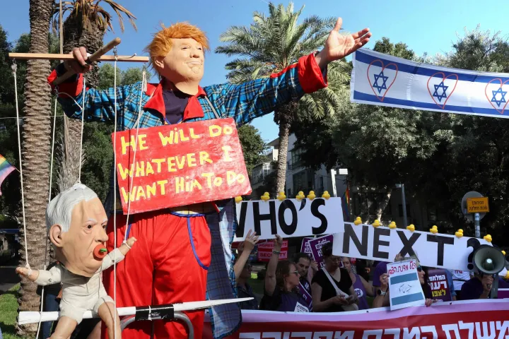 A demonstrator dressed as US President Donald Trump and holding a puppet depicting Israeli Prime Minister Benjamin Netnayahu as a baby poses as protesters gather outside the Likud party headquarters in Tel Aviv on June 4, 2026, calling for a political process to end the fighting and restore security for residents of northern Israel and soldiers. Hezbollah's chief on June 4, rejected a conditional truce announced by Lebanese and Israeli envoys, demanding instead a comprehensive ceasefire and full Israeli withdrawal as he threatened northern Israel with new attacks. (Photo by JACK GUEZ/AFP)