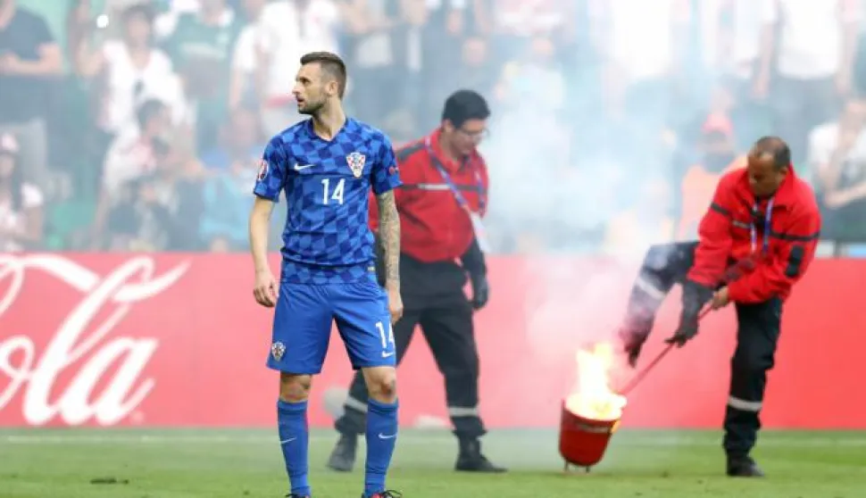 Saint-Etienne, 17.6.2016 - Utakmica 2. kola skupine E na Europskom nogometnom prvenstvu u Francuskoj: Hrvatska - Čeka. Skupina hrvatskih navijača je u 86. minuti pobacala baklje na travnjak eleći isprovocirati prekid dvoboja. Na Marcelo Brozović gleda prema tribinama od kuda su bačene baklje.foto HINA/ Damir SENČAR/ ds