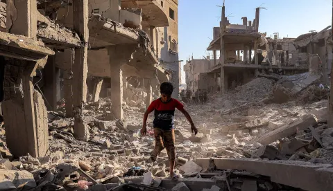 A boy walks through the rubble of a building that was destroyed following Israeli bombardment after an evacuation order, at the Maghazi camp for Palestinian refugees in the central Gaza Strip on June 12, 2026. Gaza remains gripped with daily violence despite a formal ceasefire in place since October 2025, with both the Israeli military and Hamas accusing one another of violating the truce. (Photo by Eyad Baba/AFP)