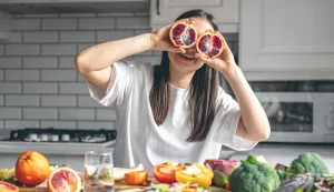 Funny young woman with orange halves in the kitchen, concept of health, weight loss and diet.Nutricionizam ilustacija