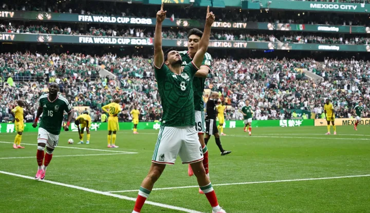 TOPSHOT - Mexico's forward #09 Raul Jimenez celebrates with teammate midfielder #19 Gilberto Mora scoring his team's second goal during the 2026 World Cup Group A football match between Mexico and South Africa at the Mexico City Stadium in Mexico City on June 11, 2026. (Photo by CARL DE SOUZA/AFP)