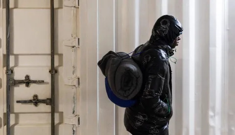 A migrant gets ready to disembark from the rescue ship "Ocean Viking" operated by the NGO SOS Mediterranee, at the port of Savona, northwestern Italy, on January 5, 2026. 33 migrants were saved by crew members of the rescue ship "Ocean Viking" operated by the NGO SOS Mediterranee on December 31, 2025. They had been stranded on the oil tanker the "Maridive 703" for 5 days in the joint search zone between Malta and Tunisia in international Mediterranean waters. (Photo by Sameer Al-DOUMY/AFP)
