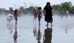 People cool off in a reflecting pool in Bordeaux, south-western France, on June 17, 2026. A heatwave will hit France on June 17, 2026 and last for several days, right in the middle of the baccalaureate exams, with temperatures that could reach up to 40?C in some areas on June 21, the first day of summer. (Photo by ROMAIN PERROCHEAU/AFP)