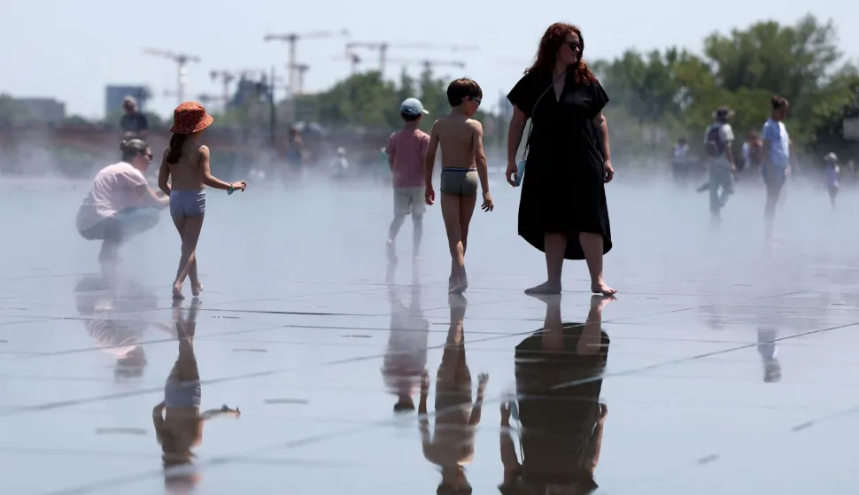 People cool off in a reflecting pool in Bordeaux, south-western France, on June 17, 2026. A heatwave will hit France on June 17, 2026 and last for several days, right in the middle of the baccalaureate exams, with temperatures that could reach up to 40?C in some areas on June 21, the first day of summer. (Photo by ROMAIN PERROCHEAU/AFP)